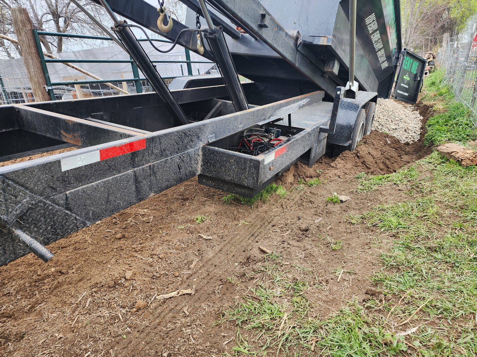 Hydraulic lift and trailer frame detail during a bin drop-off